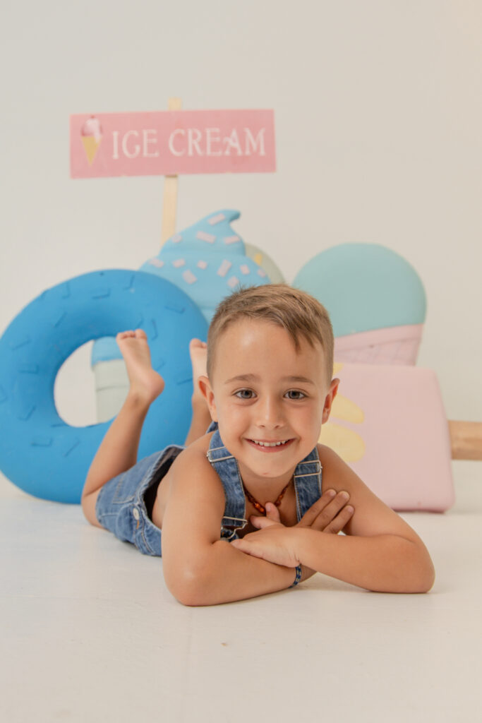 Niño disfrutando de una mini sesión de verano infantil en Girona con decorado de helados en estudio fotográfico